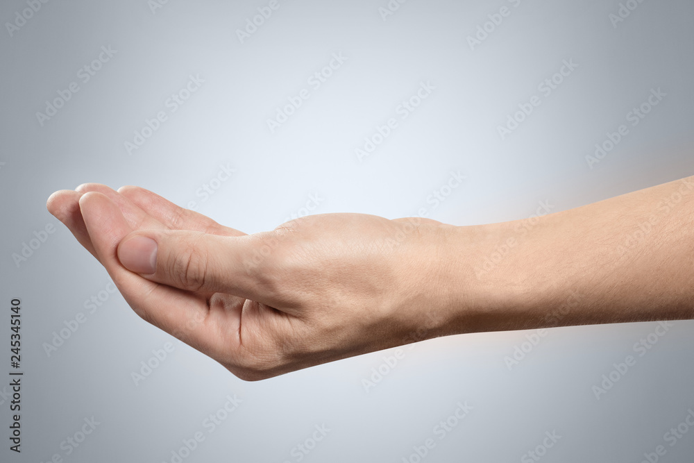 Outstretched hand gesture, holding, asking or offering something, isolated on gray background Outstretched hand gesture, holding, asking or offering something, isolated on gray background
