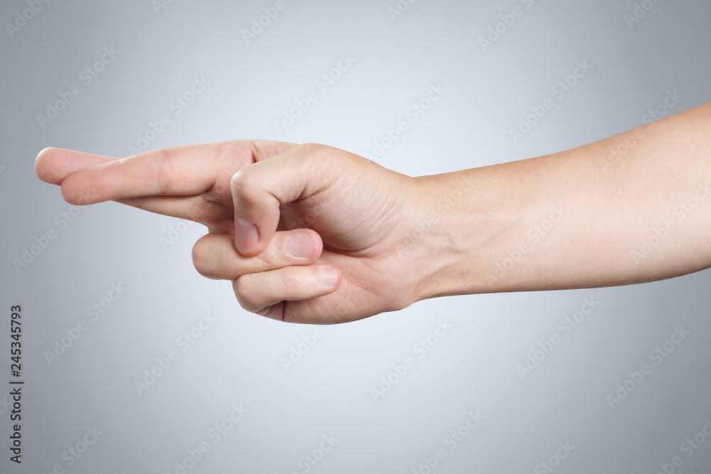 Hand showing cheating sign on gray background Hand showing cheating sign on gray background
