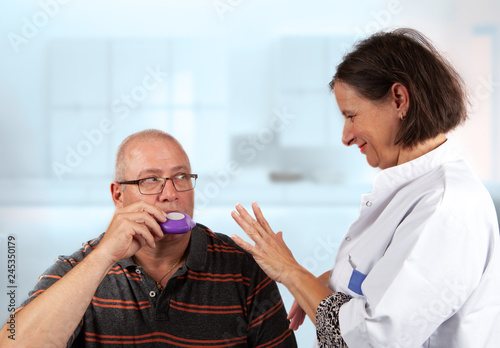 nurse explains an inhaler to a patiënt: hold breath for 5 seconds