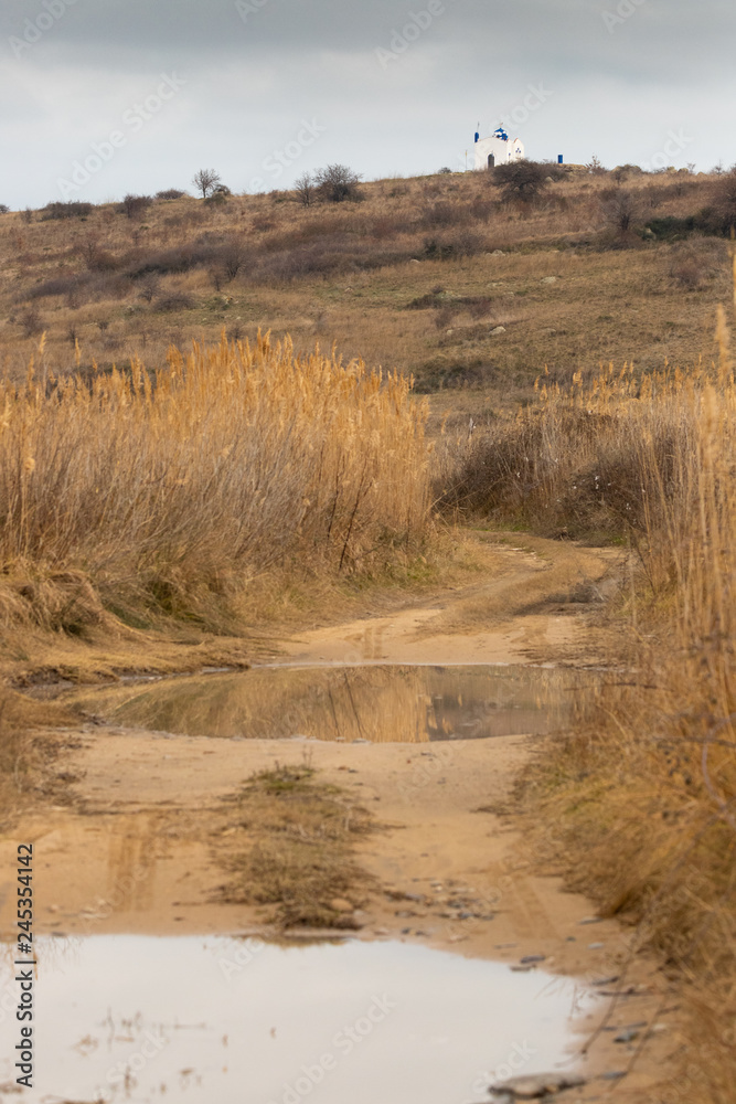Muddy path leading to a small, remote church (Agios Nikolaos) in the mountain top in Rodopi, Greece