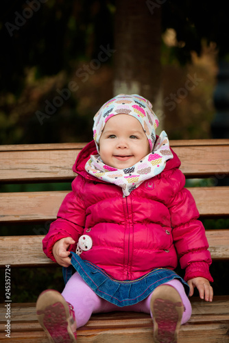 Happy little girl playing in a beautiful autumn park