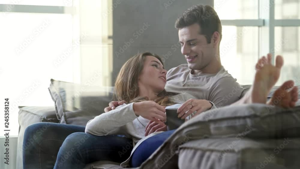Happy lovely couple having rest together while sitting on bed Happy lovely couple having rest together while sitting on bed