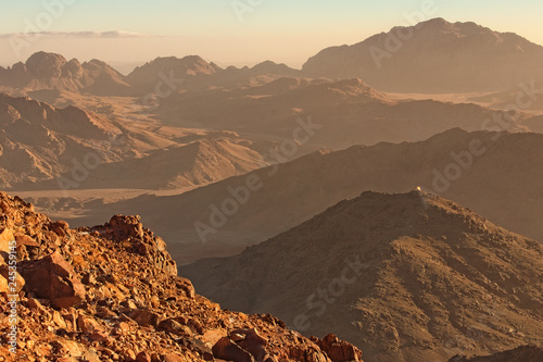Picturesque landscape of mountains peaks during sunrise. View from Mount Sinai (Mount Horeb, Gabal Musa). Sinai Peninsula of Egypt. Famous touristic place and travel destination in Egypt photo
