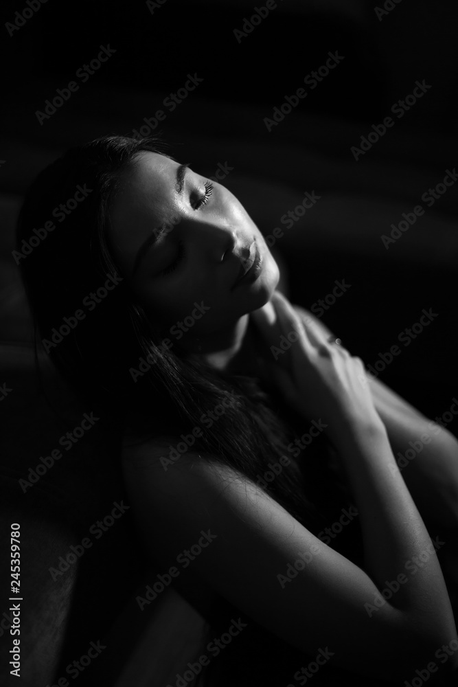 lowkey portrait of beautiful woman with closed eyes over dark background lowkey portrait of beautiful woman with closed eyes over dark background