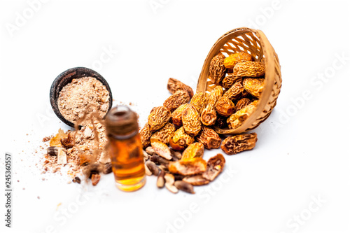 Essential oil of kharek of dried dates or sukhi khajoor or Phoenix dactylifera in a transparent glass bottle isolated on white with raw dried dates and its powder. photo