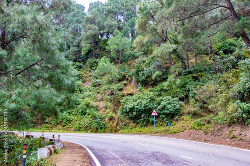 Scenic road through the valley of banikhet dalhousie himachal pradesh covered with mountain and trees. Driving uphill scenic road travel concept photo