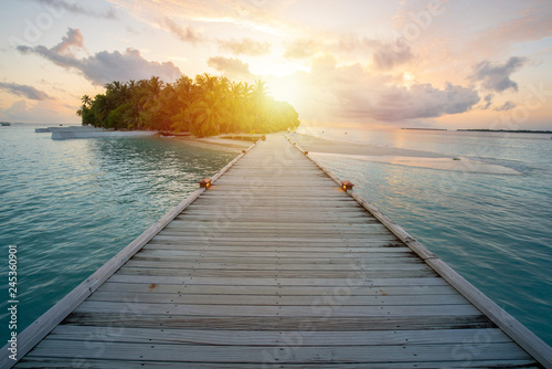 Wooden walkway into resort at Maldive  sun glare from sunset time