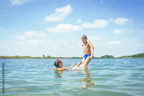 Mother and sun having fun in water on summer vacation. © LumineImages