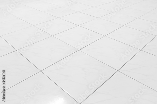 White tile floor background in perspective view. Clean, shiny, symmetry with grid line texture. For decoration in bathroom, kitchen and laundry room. And empty or copy space for product display also.