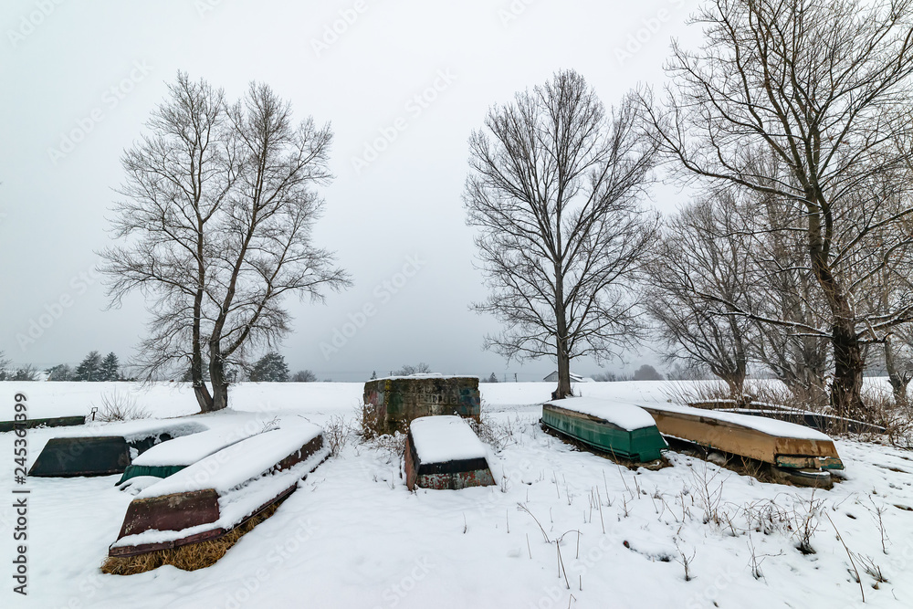 Naklejka premium A boats covered with snow on the coast