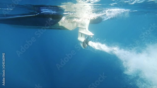 slowmotion shot of boat propeller starts with nice air bubbles turning around the propeller photo
