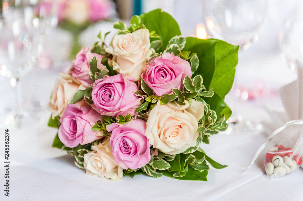 Flower bouquet of pink and yellow roses on white table