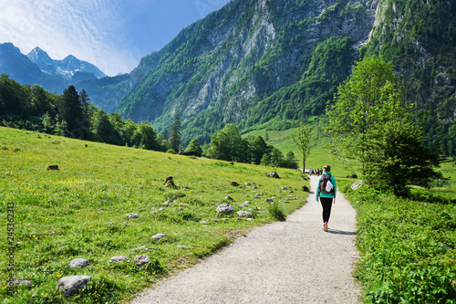 Fototapeta Naklejka Na Ścianę i Meble -  Young woman Hikers on the trail in the Scenic summer landscape view in the Alps, National park Berchtesgaden Land, Bavaria, Germany. 
