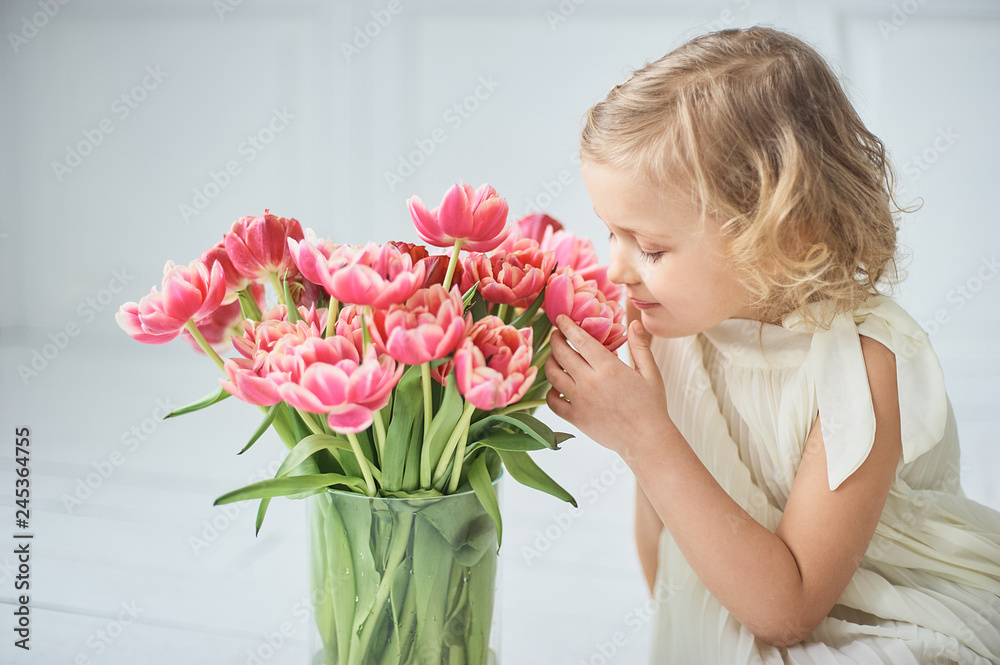 girl holding tulips in hands. Adorable smiling little girl holding flowers for her mom on mother's day. girl holding tulips in hands. Adorable smiling little girl holding flowers for her mom on mother's day.