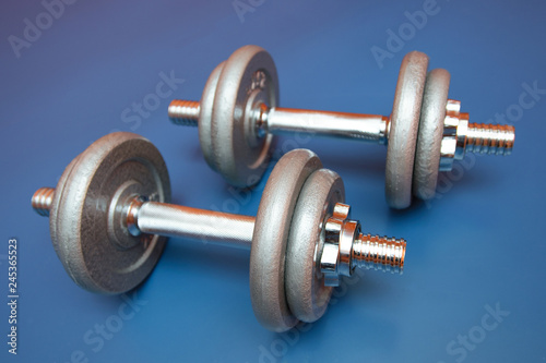 Two dumbbells on a blue background