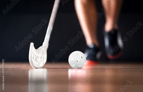 Floorball or floor hockey concept. Player running with ball and stick.