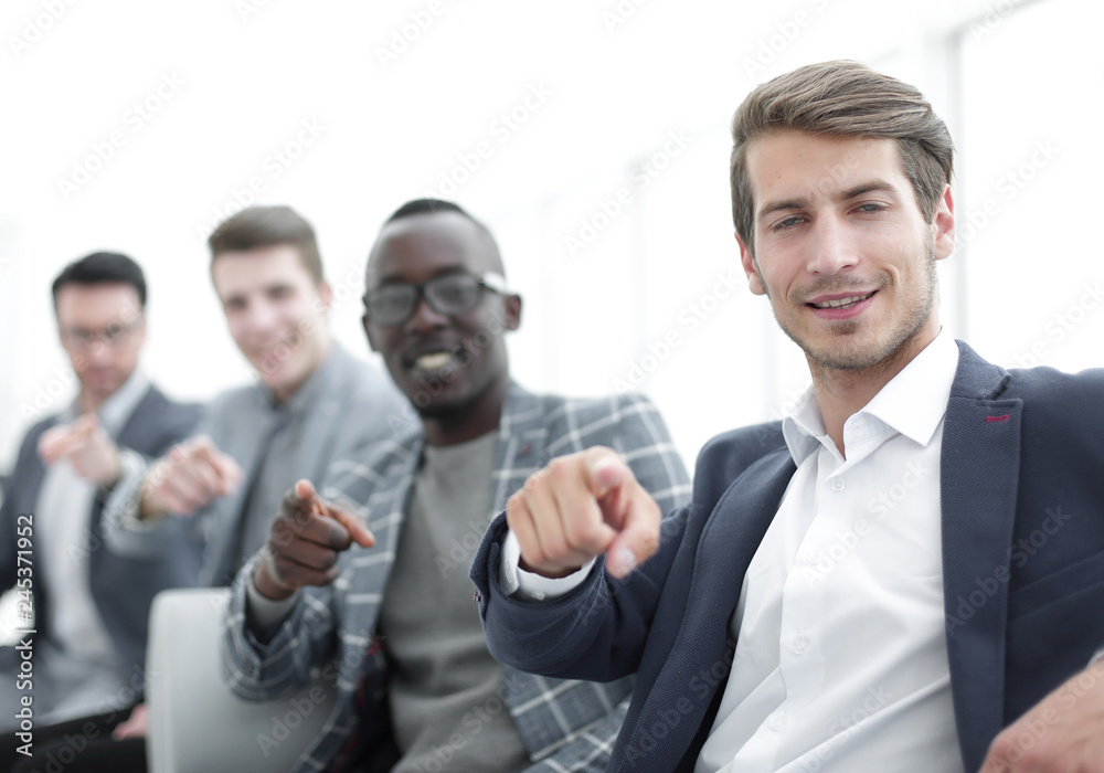 group of successful young men pointing their fingers at you group of successful young men pointing their fingers at you