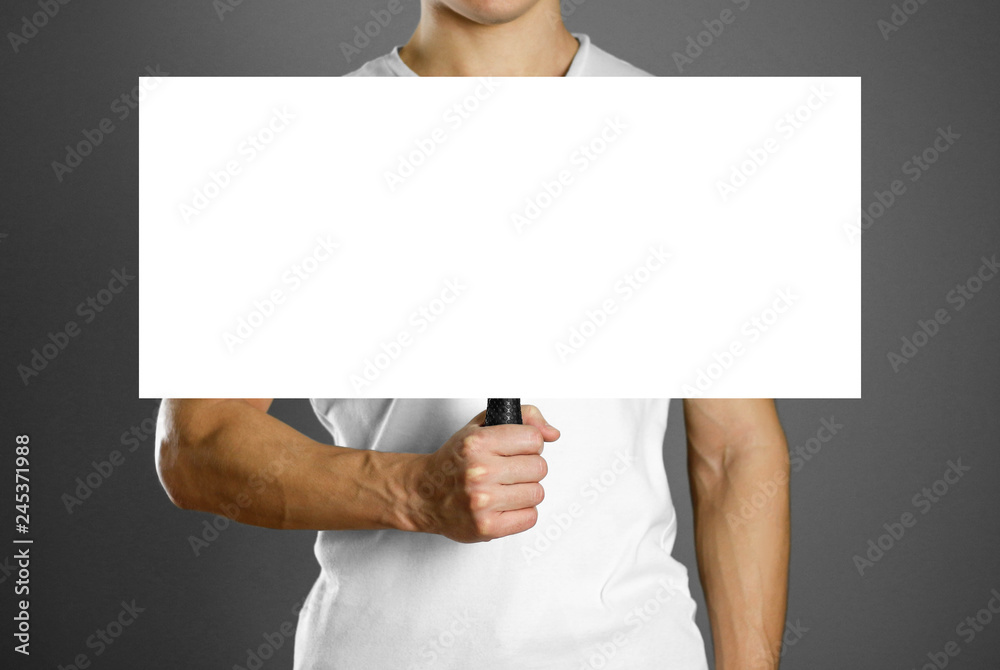 Man holding a cardboard sign with a handle. Close up. Isolated background Man holding a cardboard sign with a handle. Close up. Isolated background