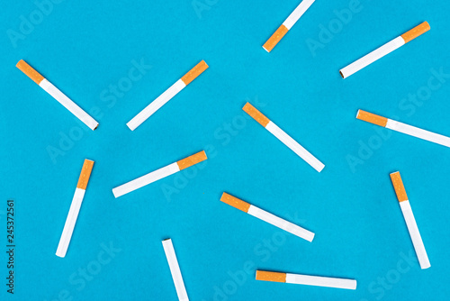 Flat lay of cigarettes isolated on blue