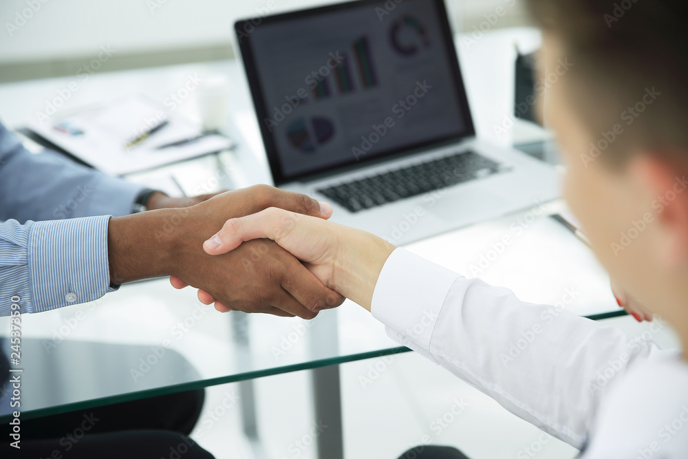 closeup.strong financial partners shaking hands over a Desk