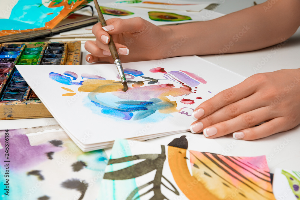 selective focus of female hands drawing in album with watercolor paints and paintbrush selective focus of female hands drawing in album with watercolor paints and paintbrush