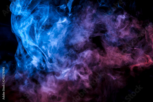 A colorful pillar of blue  pink and purple smoke evaporates with thin jets rising to the top on a black background in neon light.