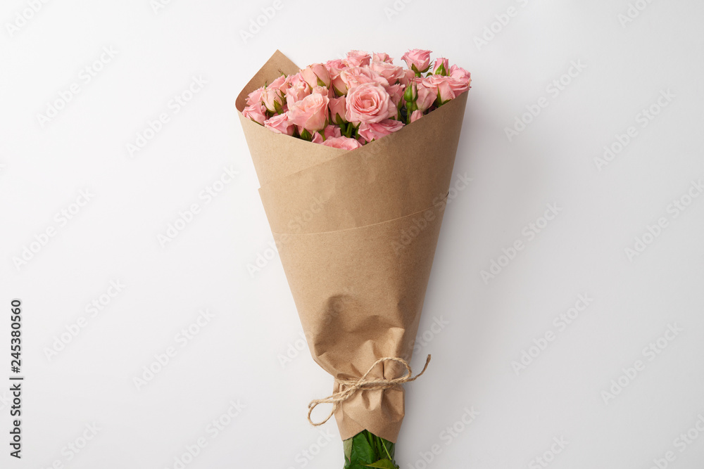 bouquet of beautiful pink roses wrapped in craft paper on grey Stock Photo  | Adobe Stock