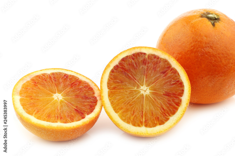 fresh blood orange and a cut one on a white background fresh blood orange and a cut one on a white background