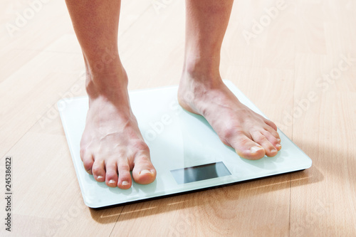 Legs on the scales. Checking the weight. Losing weight.
