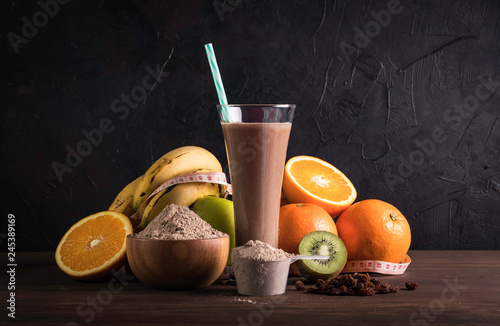 Fototapeta Naklejka Na Ścianę i Meble -  Chocolate protein shake with fruits and raisins on the wood table