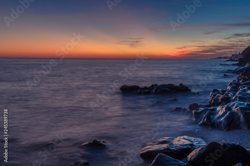 Nerja, Malaga, Andalusi, Spain - December 18, 2018: Twilight sunrise on the beach with some rocks in the front of the image