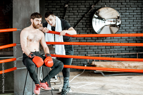 Fotografie Boxing trainer giving instructions during a break motivating a boxer sitting on