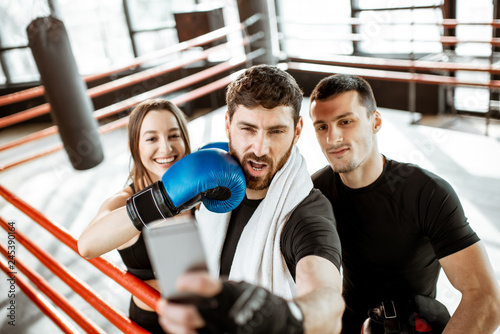Friends making selfie portrait, having fun together during the sports break after the training on the boxing ring at the gym