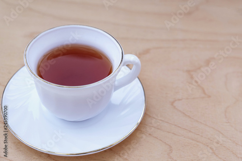 Cup of tea on light wooden background.