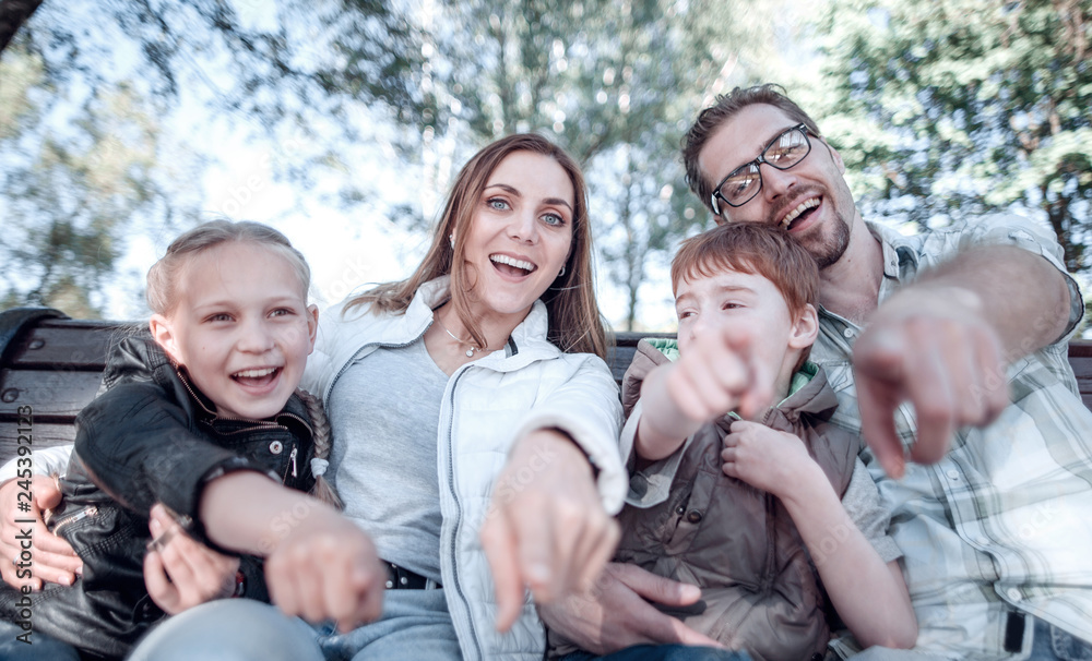 close up.smiling family pointing at you