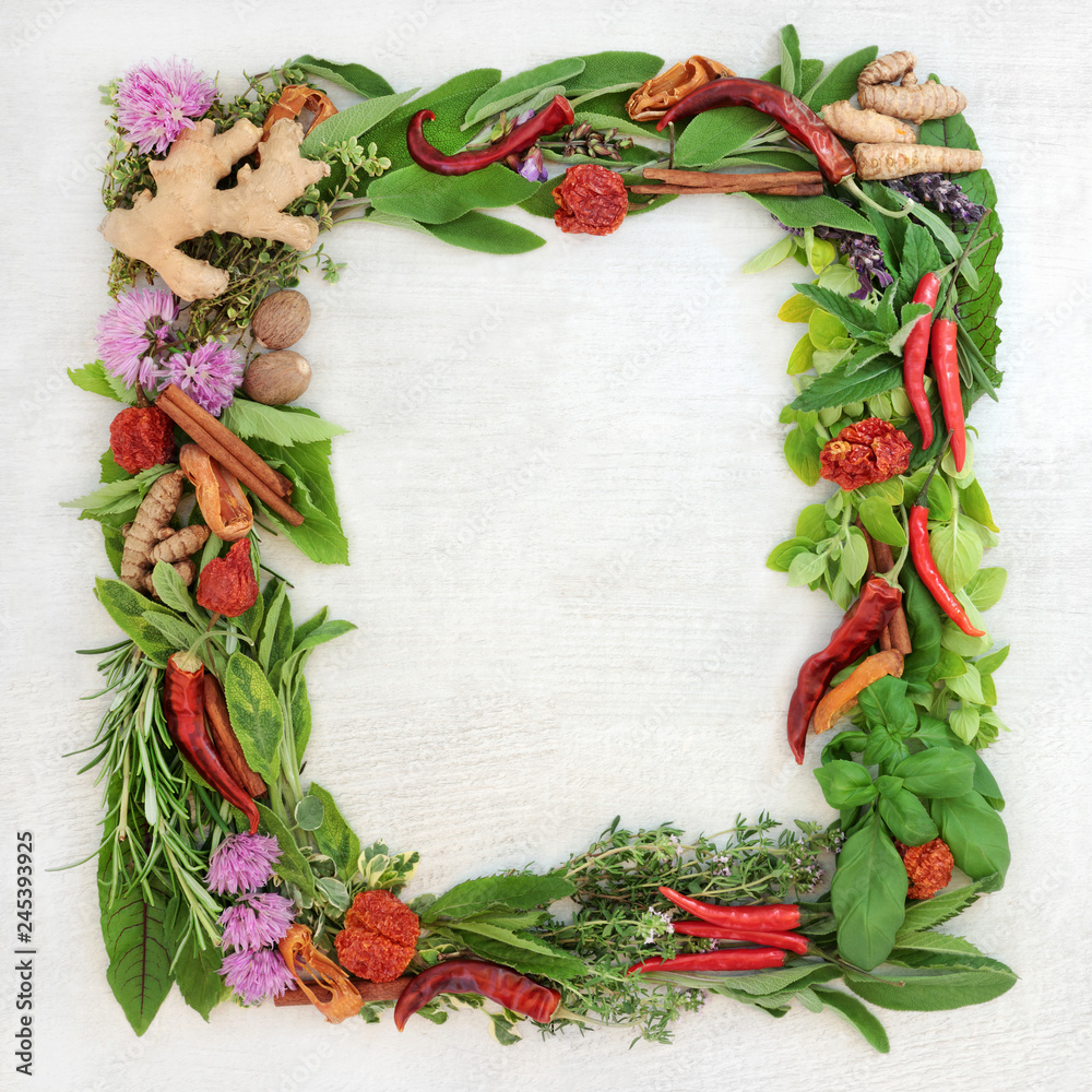 Herb leaf and spice wreath with a selection of fresh herbs with flowers on rustic wood background with copy space.
