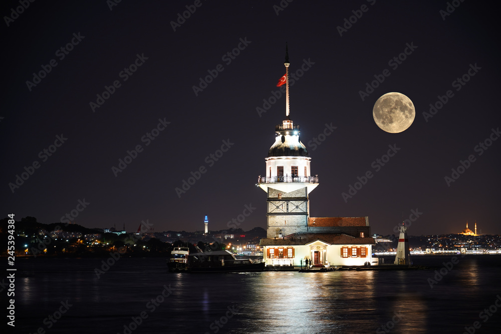 Kiz Kulesi or Maiden's Tower in Istanbul with beautiful city night and full moon.  Old historical tower - in Turkey
