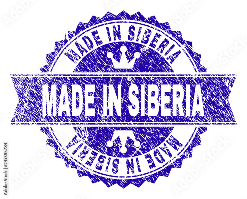 MADE IN SIBERIA rosette stamp watermark with grunge effect. Designed with round rosette, ribbon and small crowns. Blue vector rubber watermark of MADE IN SIBERIA title with grunge texture.