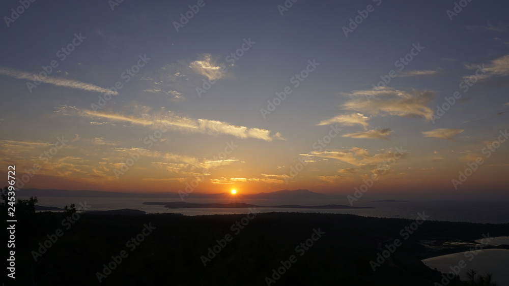 Sunset over sea at Devil's Table (Şeytan Sofrası). Bright dramatic sky and dark blue ground. Beautiful landscape under scenic colorful orange sky at sunset. Sun over skyline. Warm yellow color concept