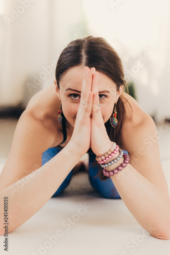 Young woman meditating and doing yoga exercise at studio