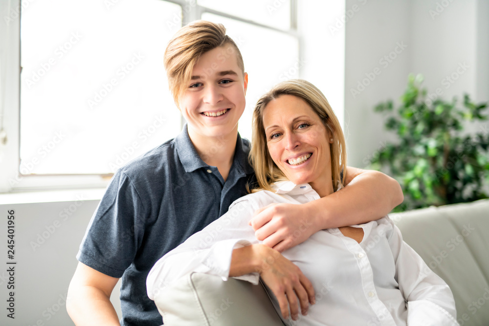 A people and family happy teen boy with mother on sofa at home A people and family happy teen boy with mother on sofa at home
