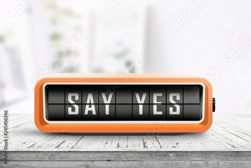 Say yes message sign on a wooden desk