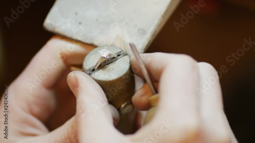 Close shot of jeweller pushing clasps tighter over gem in a ring
