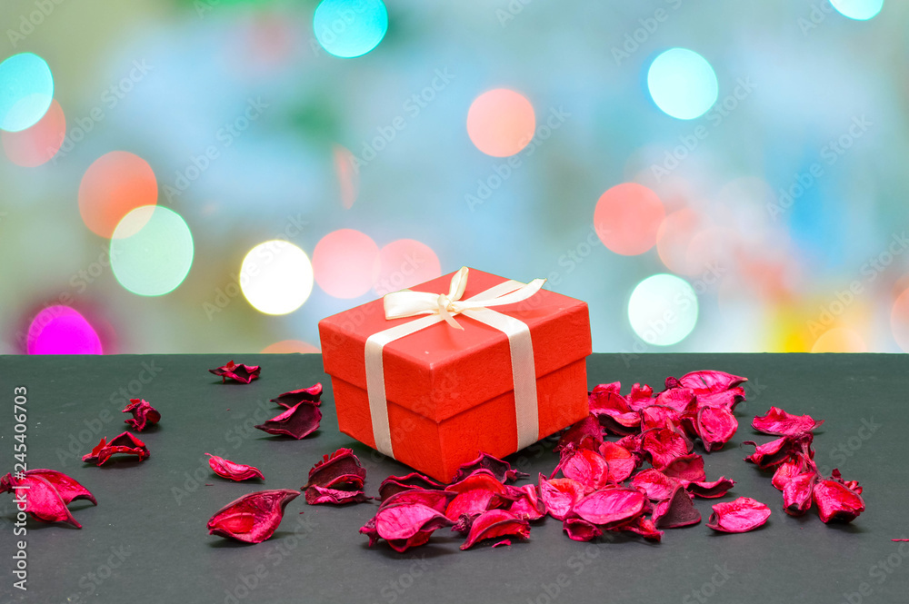Lovely Gift box in between rose petals in bokeh light background