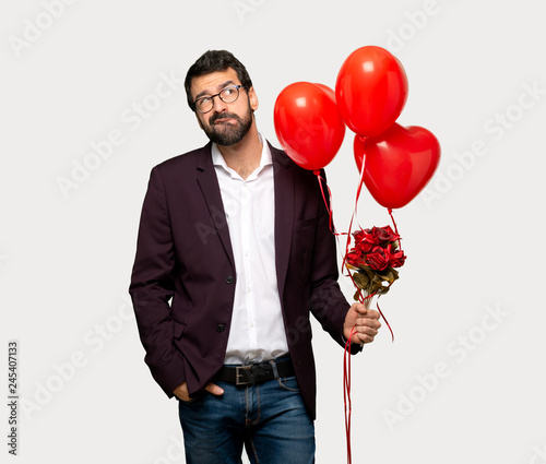 Man in valentine day with confuse face expression while bites lip over isolated grey background © luismolinero