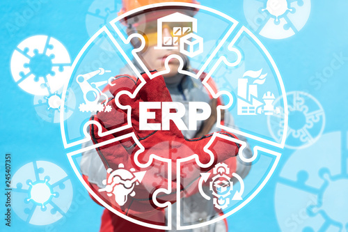 Industry worker working on a virtual screen of the future and sees the abbreviation: ERP. Erp enterprise resources planning industrial concept.