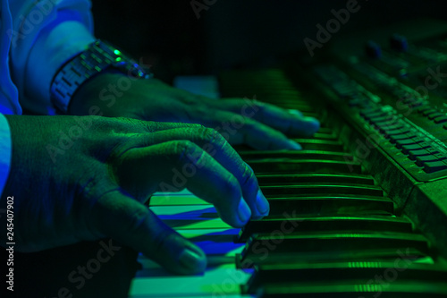 hand on green background playing piano
