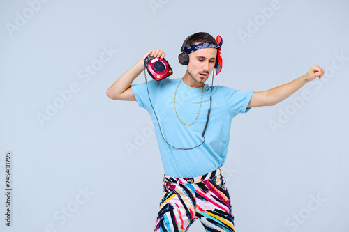 fashionable bright man in headphones in retro style manifestation of emotions of joy, gestures with hands space for text