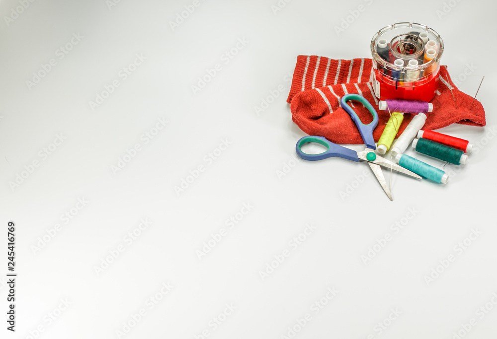 Color threads and sewing accessories on white background.