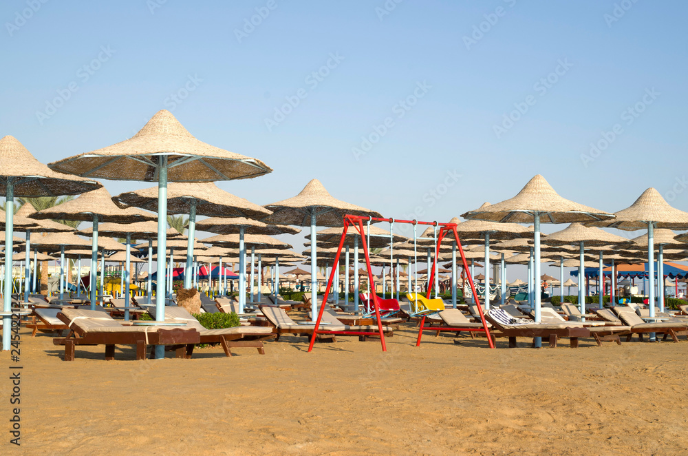 Many beach umbrella from wicker and lounge chairs, Hurgada, Egypt